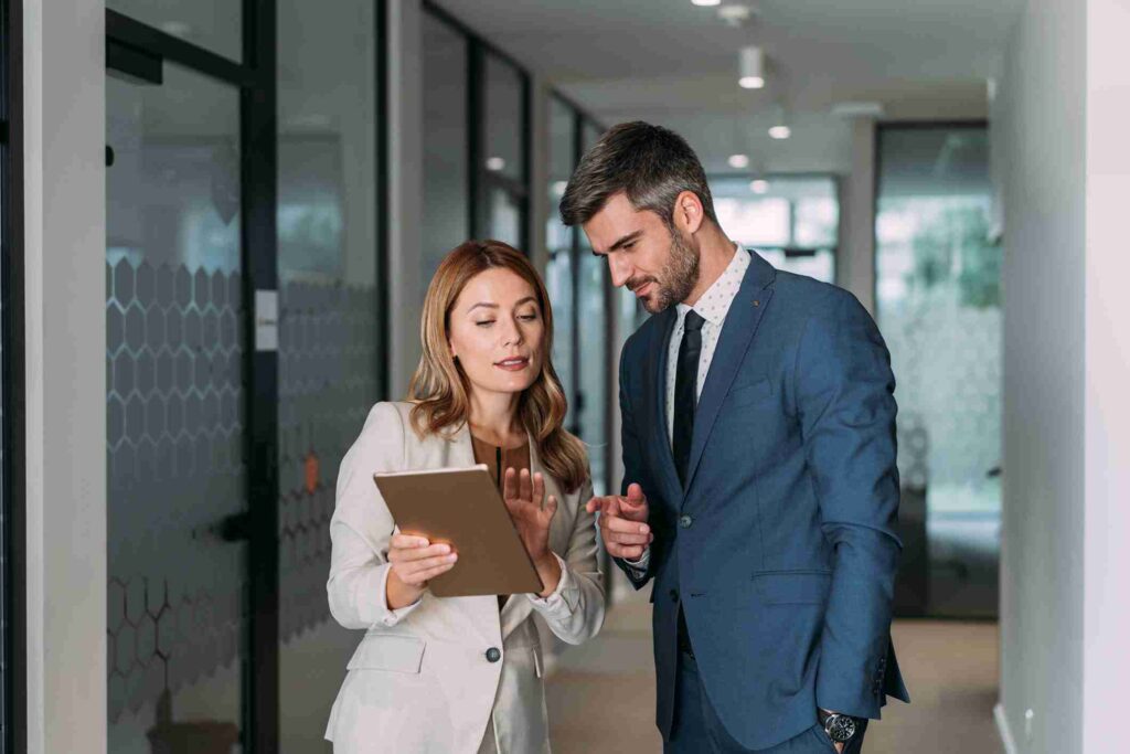 Two financial professionals discussing a report on a tablet
