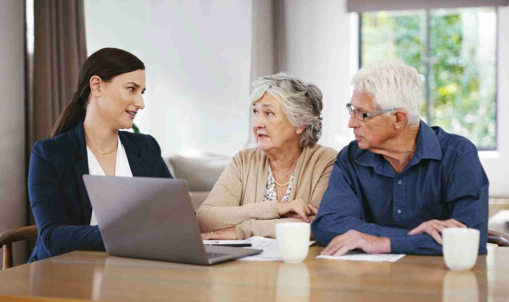 Financial advisor reviewing a plan on a laptop with a retired couple